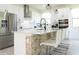 Modern kitchen with an island, stone accents, stainless steel appliances, and seating at 6617 Harper Way, Harmony, FL 34773