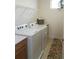 Bright laundry room features modern washer and dryer, plus counter space and shelving at 6617 Harper Way, Harmony, FL 34773