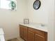 Bright laundry room featuring wooden cabinets, neutral countertop, and decorative accents at 6617 Harper Way, Harmony, FL 34773