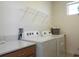 Bright laundry room features modern washer and dryer, plus counter space and shelving at 6617 Harper Way, Harmony, FL 34773