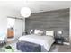 Stylish main bedroom featuring a decorative accent wall, modern lighting, and a barn door to the en suite bathroom at 6617 Harper Way, Harmony, FL 34773
