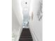 Well-lit staircase with carpeted steps, featuring a modern light fixture and decorative wall art in a bright, open space at 6617 Harper Way, Harmony, FL 34773