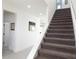 Carpeted stairway with white walls and natural light at 6617 Harper Way, Harmony, FL 34773