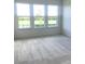 Sunlit bedroom with large windows overlooking a serene pond and lush greenery at 6806 Trellis Vine Loop, Windermere, FL 34786
