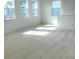 Bright living area filled with natural light from multiple windows; neutral carpet flooring at 6806 Trellis Vine Loop, Windermere, FL 34786