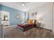 Cozy bedroom with soft carpet, a stylish bed, and light blue accent wall at 721 Drop Shot Dr, Davenport, FL 33896