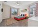 Cozy bedroom with bright red accents, a patterned bedspread, and large windows for ample natural light at 721 Drop Shot Dr, Davenport, FL 33896