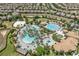An aerial view of the community pool, with its multiple pools, beach volleyball and palm trees at 721 Drop Shot Dr, Davenport, FL 33896