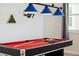 Close-up of a pool table with a red surface, cues, and a blue pendant light fixture above at 721 Drop Shot Dr, Davenport, FL 33896