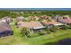 An aerial view of a well-manicured backyard featuring a screened-in lanai, lush landscaping, and a pond at 772 San Raphael St, Kissimmee, FL 34759