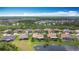 A stunning aerial view of a neighborhood with tile roofs, ponds, and lush trees under a blue sky at 772 San Raphael St, Kissimmee, FL 34759