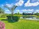 Picturesque backyard with vibrant greenery, tropical landscaping, and a tranquil lake visible through the metal fence at 772 San Raphael St, Kissimmee, FL 34759