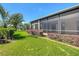 Fenced-in backyard with lush green grass, mature landscaping, and views of the screened lanai at 772 San Raphael St, Kissimmee, FL 34759