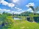 Landscaped backyard featuring a fence, manicured lawn, and serene lake views for relaxation at 772 San Raphael St, Kissimmee, FL 34759