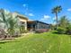 View of backyard showing a screened lanai off the back of a home with lush landscaping at 772 San Raphael St, Kissimmee, FL 34759
