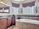 Well lit bathroom featuring a soaking tub with glass block windows and vanity at 772 San Raphael St, Kissimmee, FL 34759