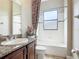Bright bathroom featuring a granite countertop, tiled bathtub with shower and decorative curtains at 772 San Raphael St, Kissimmee, FL 34759
