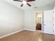Bedroom with wood flooring, ceiling fan, and an open bathroom at 772 San Raphael St, Kissimmee, FL 34759