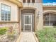Charming home entrance featuring a screened door, stone accents, and manicured landscaping at 772 San Raphael St, Kissimmee, FL 34759