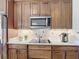 A kitchen with stainless steel appliances, a smooth cooktop, granite countertops, and wood cabinets at 772 San Raphael St, Kissimmee, FL 34759