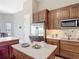 Kitchen with stainless steel appliances, wood cabinets, granite countertops, and decorative backsplash at 772 San Raphael St, Kissimmee, FL 34759