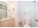 Well-lit bathroom featuring a sink, toilet, shower-tub with curtain, and beige vanity at 8217 Fan Palm Way, Kissimmee, FL 34747
