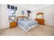 Bright bedroom featuring a queen-size bed, coordinating furniture, and ample natural light from large windows at 8217 Fan Palm Way, Kissimmee, FL 34747