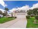 Lovely two-story home features a well-manicured lawn, mature landscaping, and attached two-car garage at 8217 Fan Palm Way, Kissimmee, FL 34747