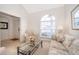 Comfortable living room with a large window providing natural light, neutral colors, and glass table at 8217 Fan Palm Way, Kissimmee, FL 34747