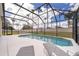 Inviting screened pool with lounge furniture and views of mature trees, creating a private oasis at 8217 Fan Palm Way, Kissimmee, FL 34747