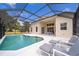 Enjoy a refreshing dip in the screened-in pool, complete with comfortable lounge chairs and an outdoor dining area at 8217 Fan Palm Way, Kissimmee, FL 34747
