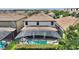 Aerial view of the pool area surrounded by lush greenery and neighboring houses at 9163 Wedge Dr, Davenport, FL 33896