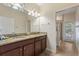Bathroom with double sinks, granite countertops, and a separate glass-enclosed shower at 9163 Wedge Dr, Davenport, FL 33896
