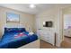 Comfortable bedroom with white furnishings, window with blinds, and a mounted TV on the wall at 9163 Wedge Dr, Davenport, FL 33896