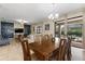 Open-concept dining room with a large wooden table, tile floors, and view of the pool area at 9163 Wedge Dr, Davenport, FL 33896