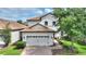Charming two-story home featuring a red-tiled roof, two-car garage and a well-manicured front yard at 9163 Wedge Dr, Davenport, FL 33896