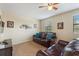 Cozy living room with leather seating, ceiling fan, and comic book decor at 9163 Wedge Dr, Davenport, FL 33896