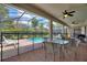 Relaxing screened-in pool area with seating, a safety fence and a lush green landscape at 9163 Wedge Dr, Davenport, FL 33896