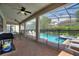 Relaxing screened-in pool area with seating, a safety fence and a lush green landscape at 9163 Wedge Dr, Davenport, FL 33896