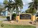 A welcoming sign for The Villas of Somerset, a vacation rental property, amidst lush landscaping at 2721 N Poinciana Blvd # 163, Kissimmee, FL 34746