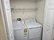 Stacked washer and dryer in a small laundry room with shelving at 2721 N Poinciana Blvd # 163, Kissimmee, FL 34746