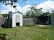 Fenced backyard featuring a small shed and lush greenery at 1004 Catherine St, Kissimmee, FL 34741