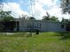 Backyard with a small fence, lawn, and the home's exterior at 1004 Catherine St, Kissimmee, FL 34741