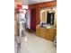 An interior hallway featuring tiled flooring and decorative display cabinet with clothing rack at 1004 Catherine St, Kissimmee, FL 34741