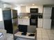 A modern kitchen with stainless steel refrigerator, white appliances, and a gray backsplash at 1004 Catherine St, Kissimmee, FL 34741