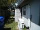 Functional side yard featuring an AC unit and storage, optimizing outdoor space with necessary utilities at 1004 Catherine St, Kissimmee, FL 34741