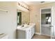 Bathroom with dual sinks, white cabinetry, a large mirror, and a view into another room at 1038 Sabine Pl, Kissimmee, FL 34759