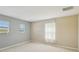 Minimalist bedroom featuring neutral tones, two windows, and natural light at 1038 Sabine Pl, Kissimmee, FL 34759