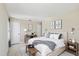 Well-lit bedroom with neutral walls, includes desk, wall art, bench, and comfortable bed at 1038 Sabine Pl, Kissimmee, FL 34759