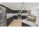 Kitchen features dark cabinets, stainless steel appliances, subway tile backsplash, and white countertops at 1038 Sabine Pl, Kissimmee, FL 34759